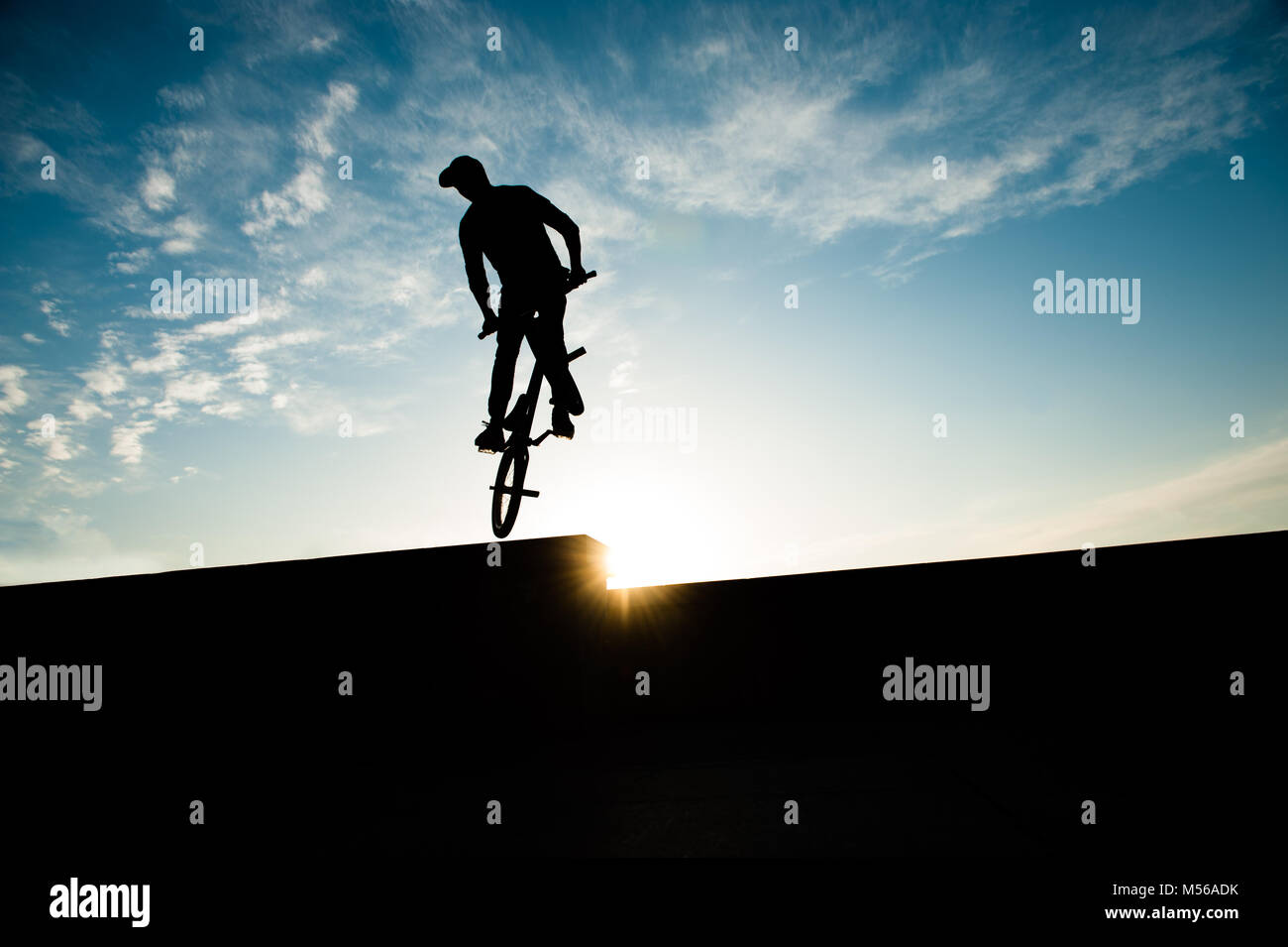 Silhouette einer Biker springen auf das Fahrrad auf Sonnenuntergang Himmel Hintergrund Stockfoto