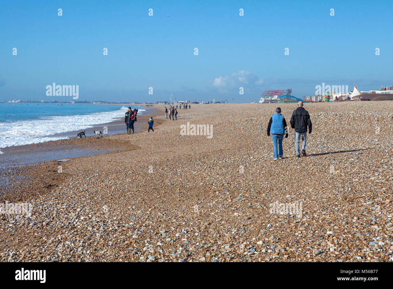 Menschen und Hunde genießen die Februar Sonnenschein am Strand von Hayling Island Stockfoto