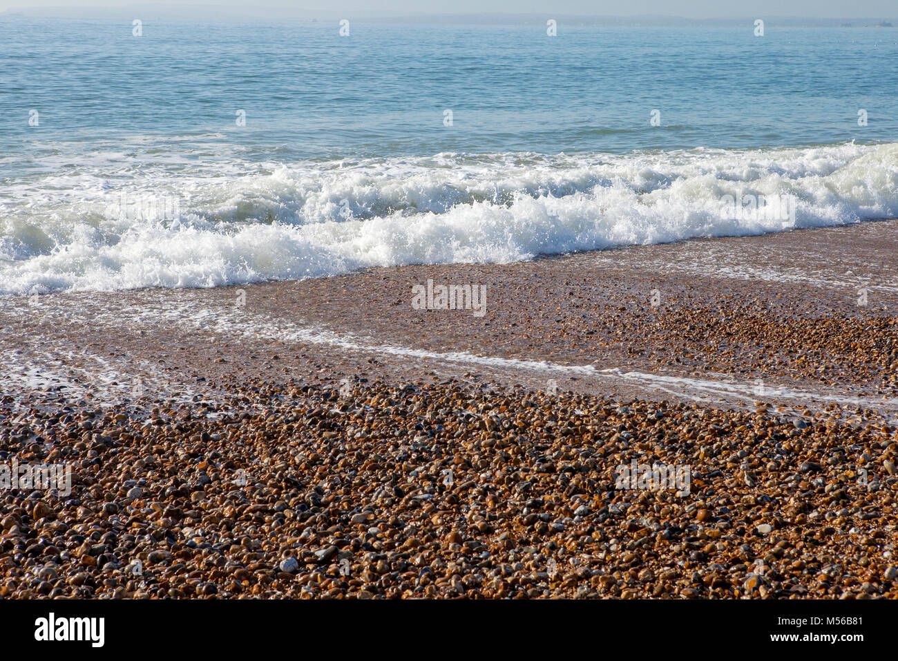 Wellen auf einem Kieselstrand Stockfoto