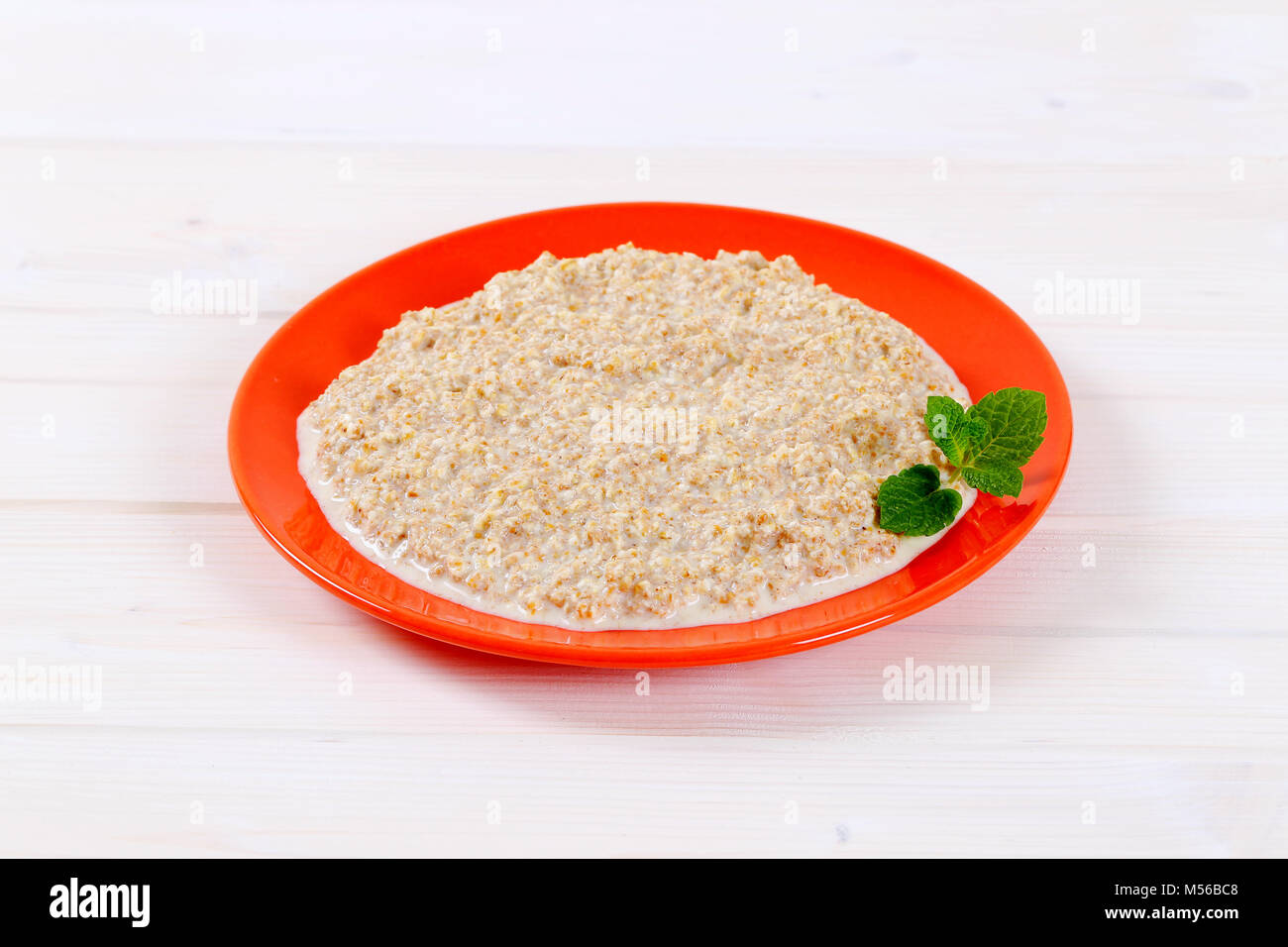 Platte von haferflocken Porridge auf weißem Hintergrund Stockfoto