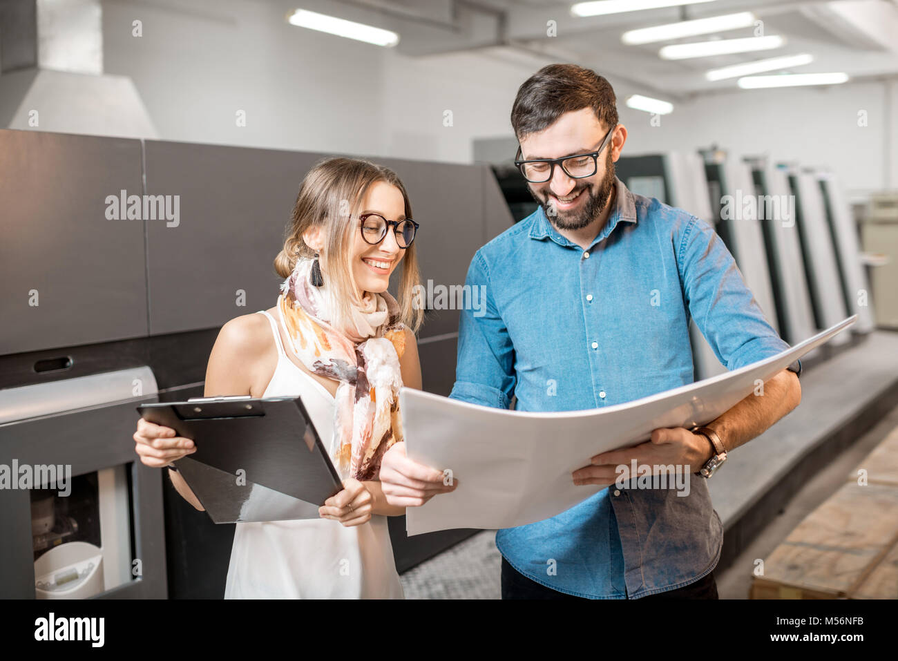 Frau mit Druckerbediener in der Fertigung Stockfoto