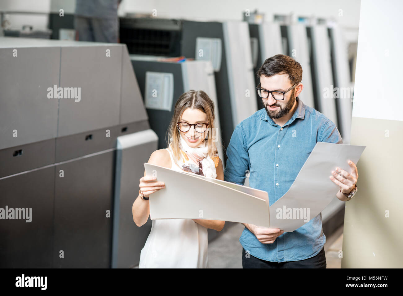 Frau mit Druckerbediener in der Fertigung Stockfoto