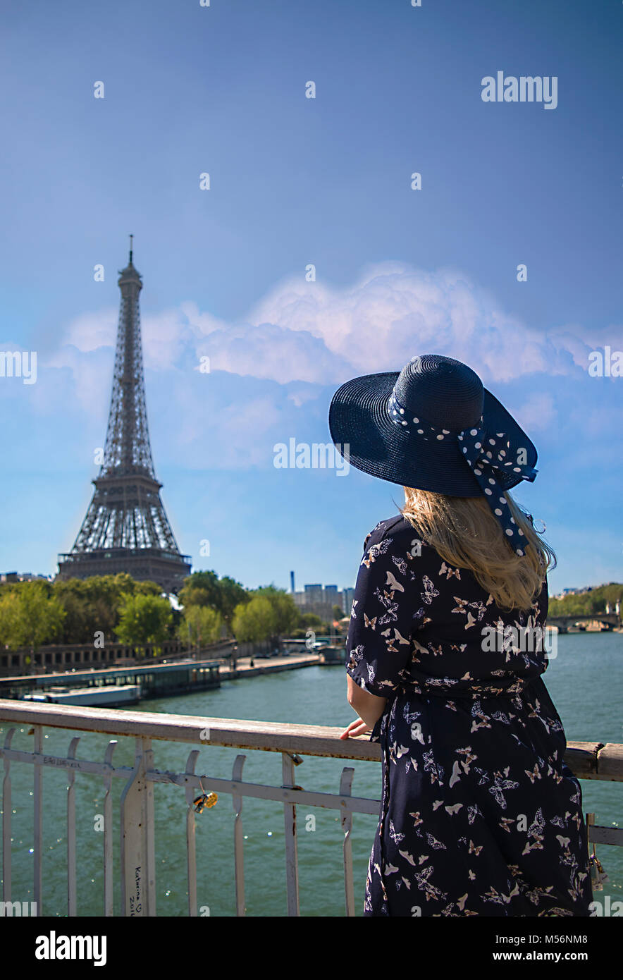 Mit Blick auf den Eiffelturm Dame gerade ist es mit wunderschönen Stadt und Himmel Hintergrund. Dame zeigt mit zurück zur Kamera. Lady ist Stockfoto