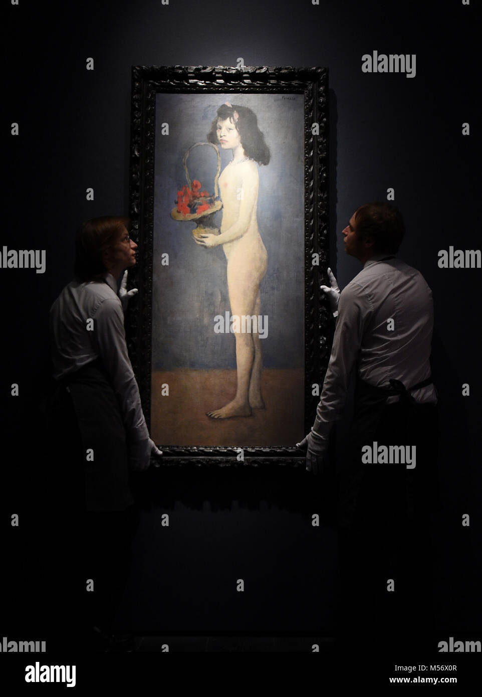 Galerie Assistenten begradigen Fillette a La Corbeille Fleurie von Pablo Picasso (1905) während ein Foto für Highlights aus der Sammlung von Peggy und David Rockefeller bei Christie's in London. Stockfoto
