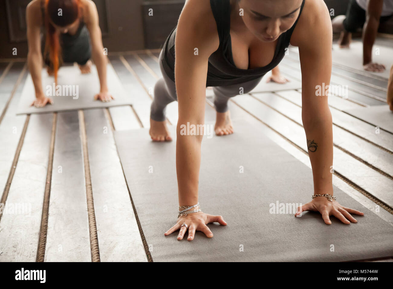 Frau und einer Gruppe von sportlichen Menschen in den Liegestütz Stockfoto
