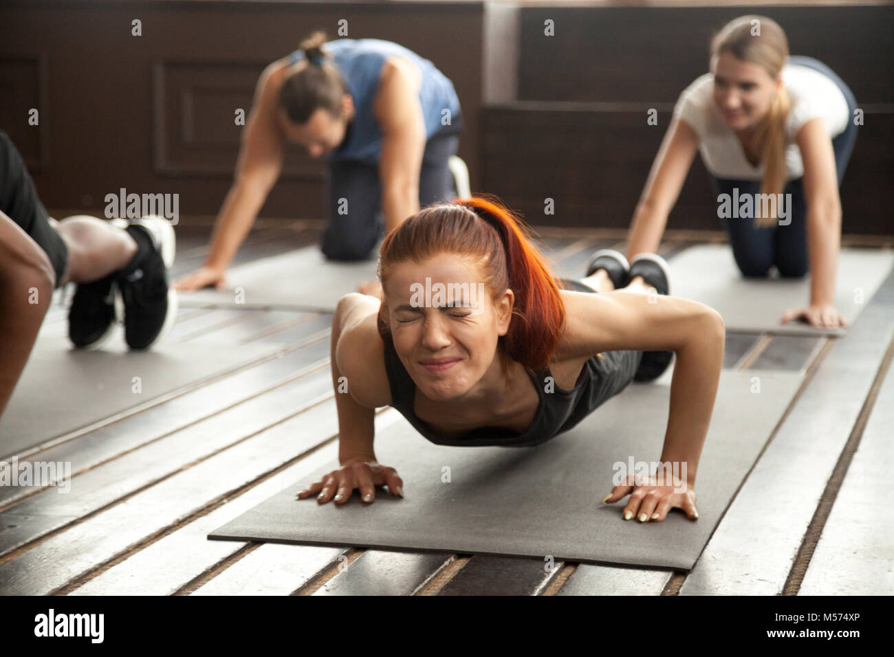 Frau tun schwierig Plank übung oder Liegestütze auf Gruppe Trainin Stockfoto