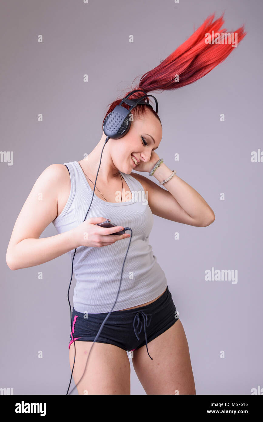 Sportliche junge Frau tanzen zu Musik Stockfoto