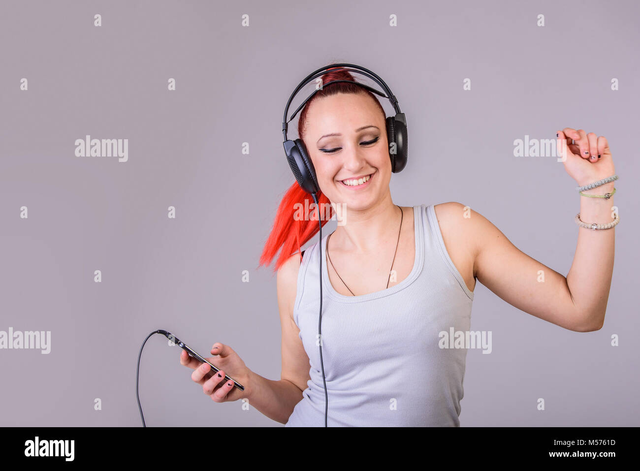Sportliche junge Frau tanzen zu Musik Stockfoto
