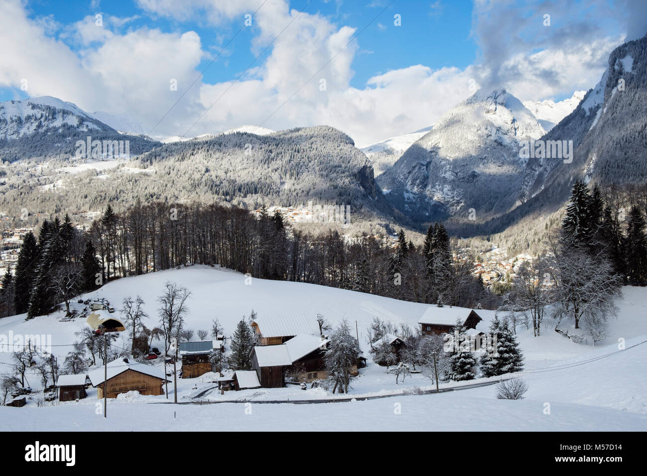 Blick über traditionelle Chalets am Berghang mit Winterschnee auf den Bergen in den französischen Alpen über dem Dorf Samoens, Vallée du Giffre, Frankreich, EU Stockfoto