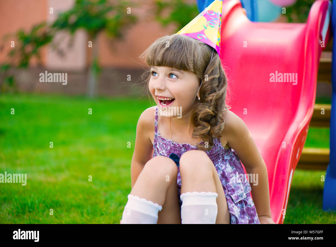 Hübsches kleines Mädchen Spaß haben auf dem Spielplatz während der Geburtstagsfeier Stockfoto