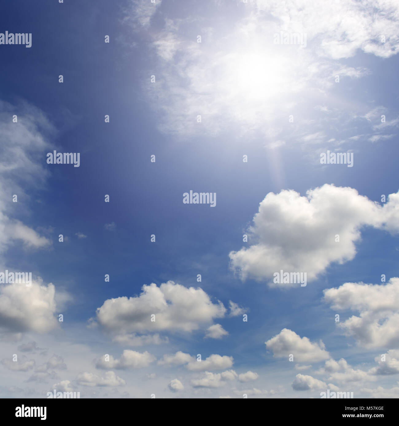 Helle Sonne im blauen Himmel unter weißen Wolken. Stockfoto