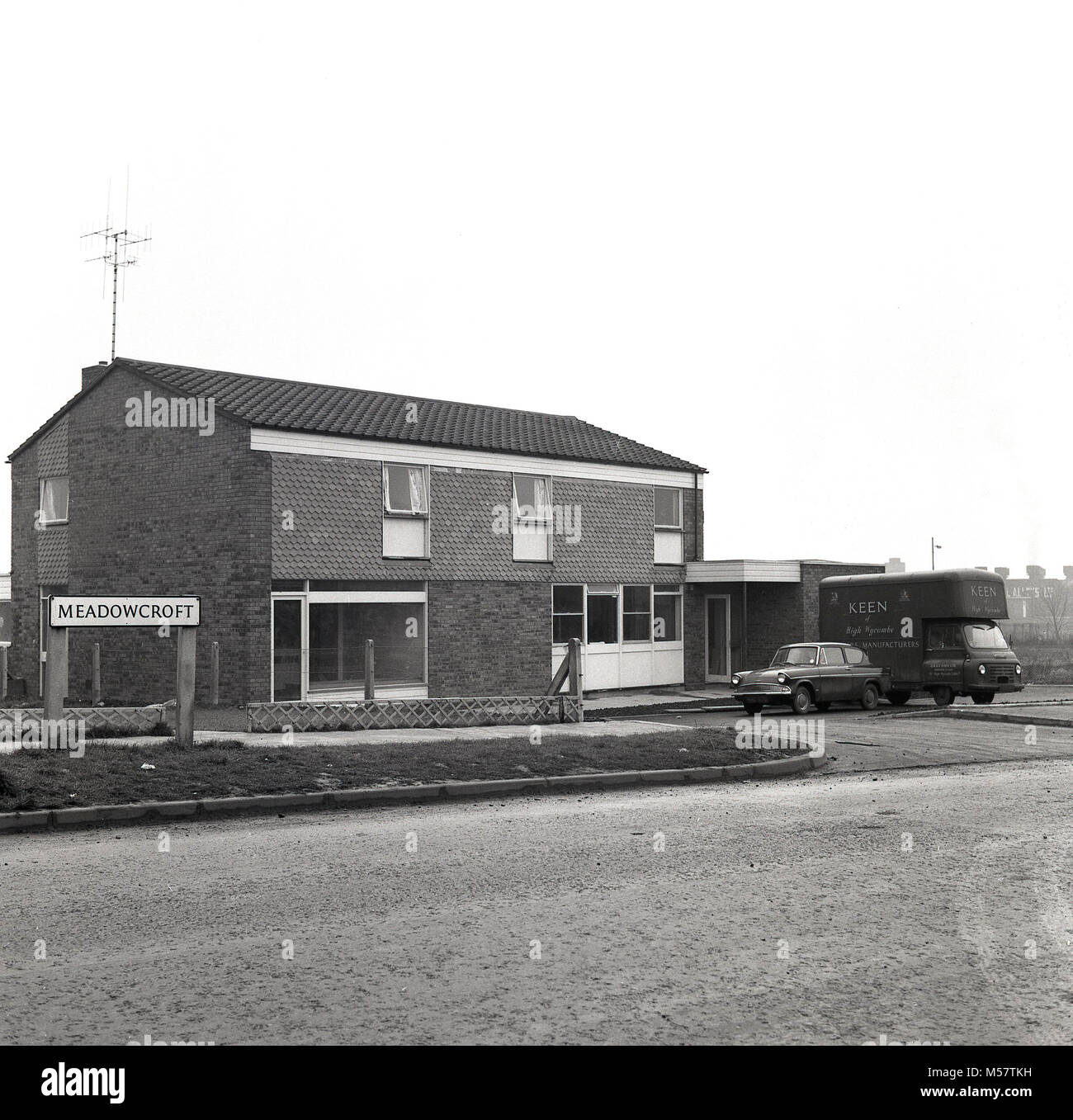 1965, historische Bild zeigt ein neues Gebäude auf einer Wohnsiedlung vor kurzem Am Meadowcroft, Aylesbury, England, Großbritannien gebaut. Das Gebäude ursprünglich konzipiert als ein Haus oder zwei Häuser würden angepasst werden eine Gemeinschaft Pub, der John Kennedy, benannt nach dem berühmten amerikanischen Präsident, JFK. Stockfoto