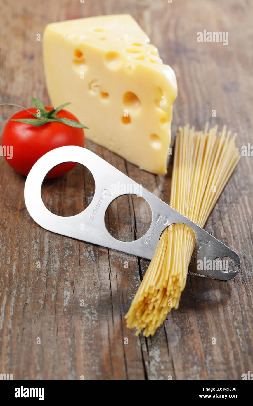 Spaghetti portionierer Stück gelbe Käse und Tomaten Stockfoto