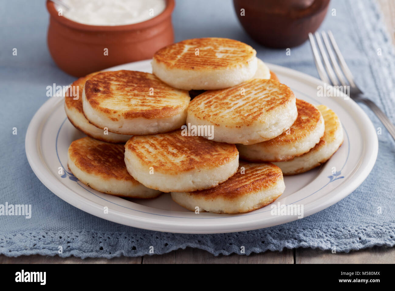 Syrniki, die traditionelle russische Käse Pfannkuchen auf einer rustikalen Tisch Stockfoto