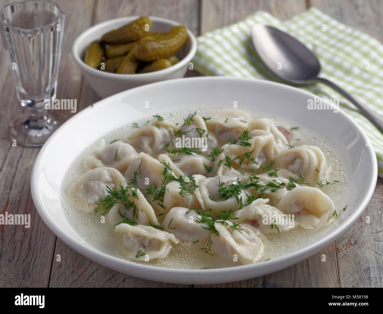 Die maultaschen der traditionellen russischen Knödel serviert mit Brühe und Dill Stockfoto