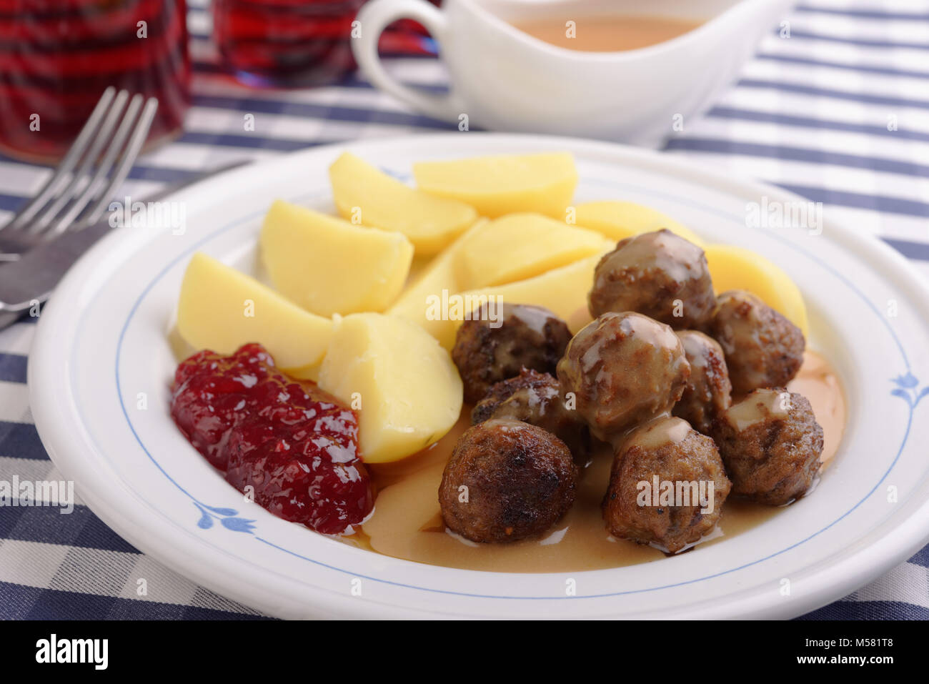 Schwedische Fleischbällchen mit gekochte Kartoffel, preiselbeere Marmelade und Sahne Sauce Stockfoto