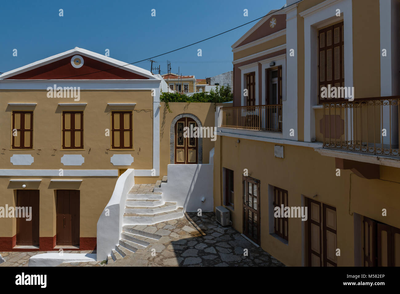 Neoklassische Wohnungen entlang Kali Strata, die massive Steintreppe, die obere Altstadt und dem Hafen verbindet, in Symi, Griechenland. Stockfoto