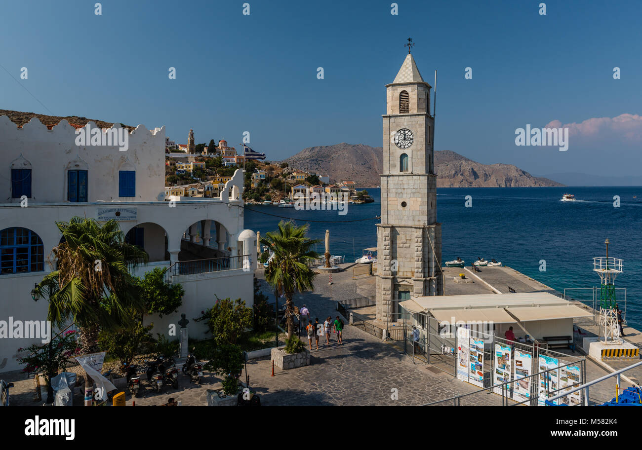 Der Uhrturm und die Einfahrt in den Hafen von Symi (Simi), eine kleine Insel der Dodekanes in Griechenland. Stockfoto