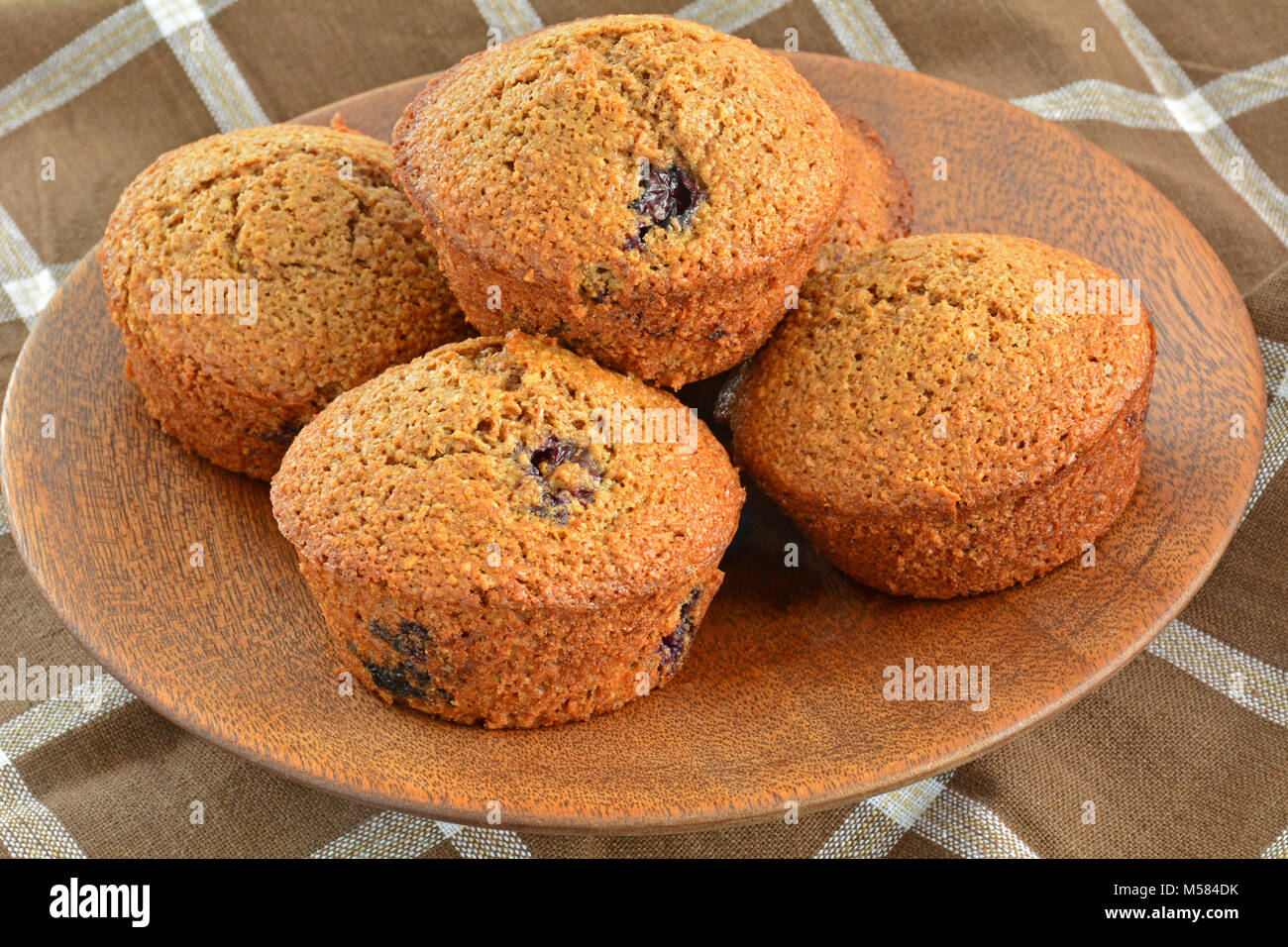 Frisch aus dem Ofen mit hausgemachten blueberry muffins Bran auf rustikalen hölzernen Platte im Querformat und schoss in natürlichem Licht Stockfoto