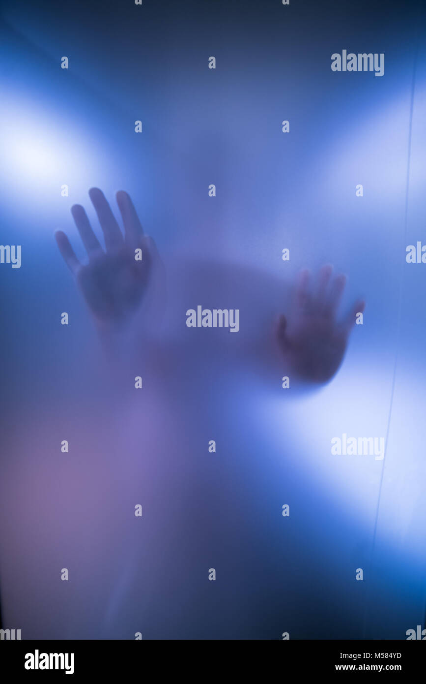 Silhouette der Frau die Hände hinter blauen Glas Stockfoto