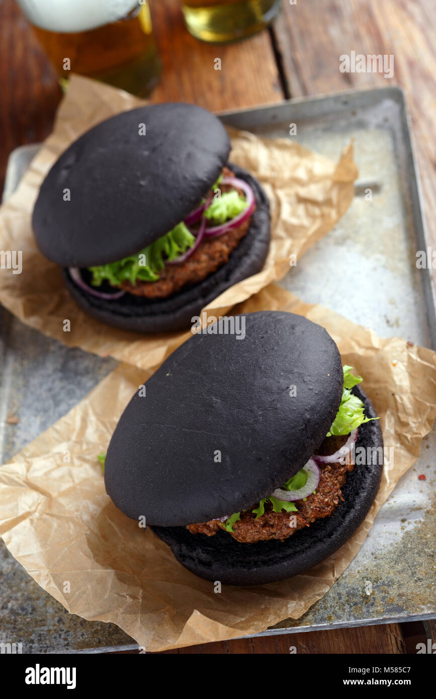 Zwei schwarze Burger auf einem Papier wickeln Stockfoto