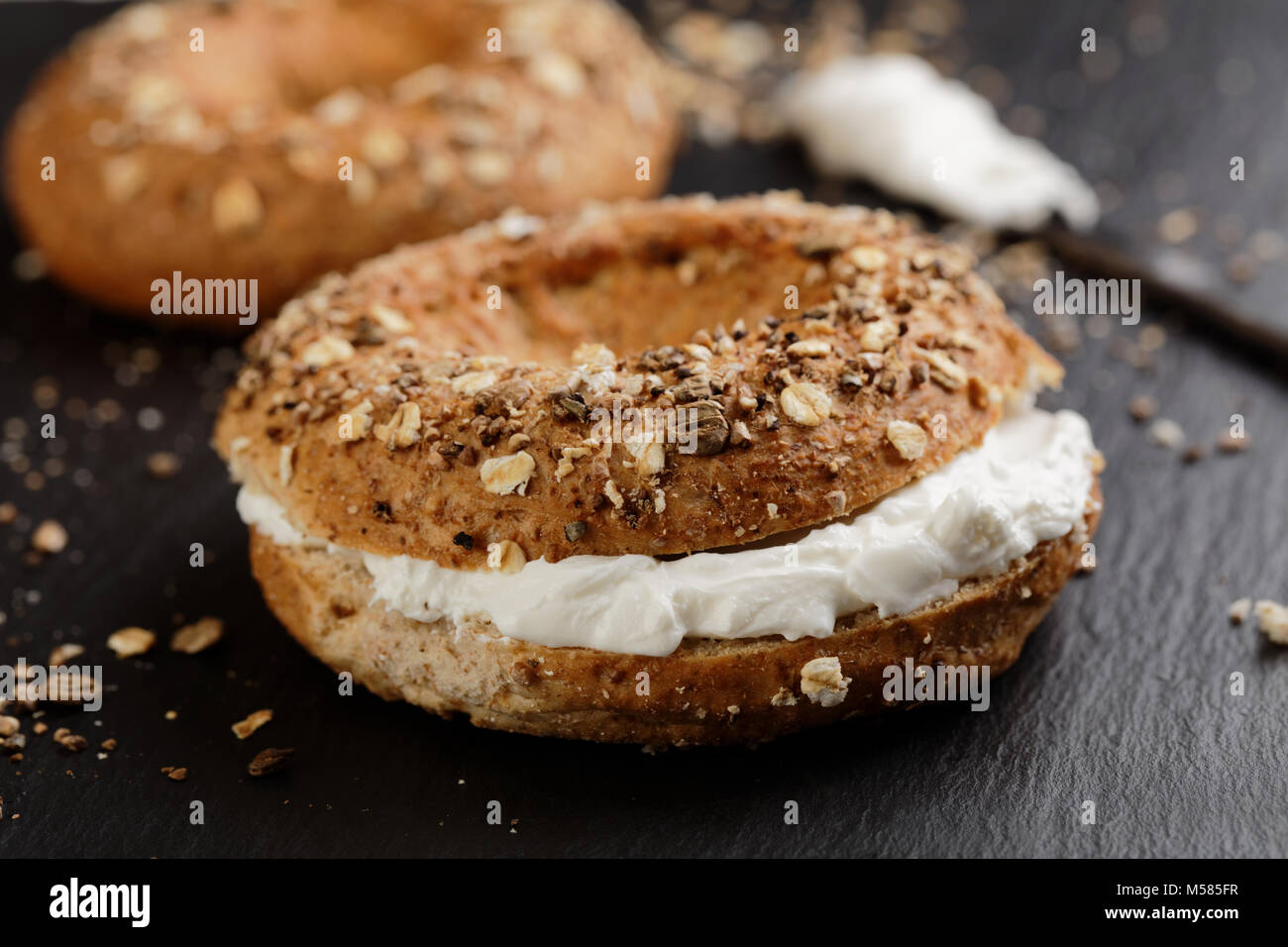 Sandwich Bagel mit Frischkäse auf einer Schiefertafel Schneidebrett Stockfoto