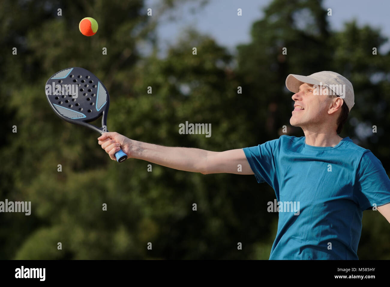 Reifer Mann spielen Beach Tennis am Strand Stockfoto