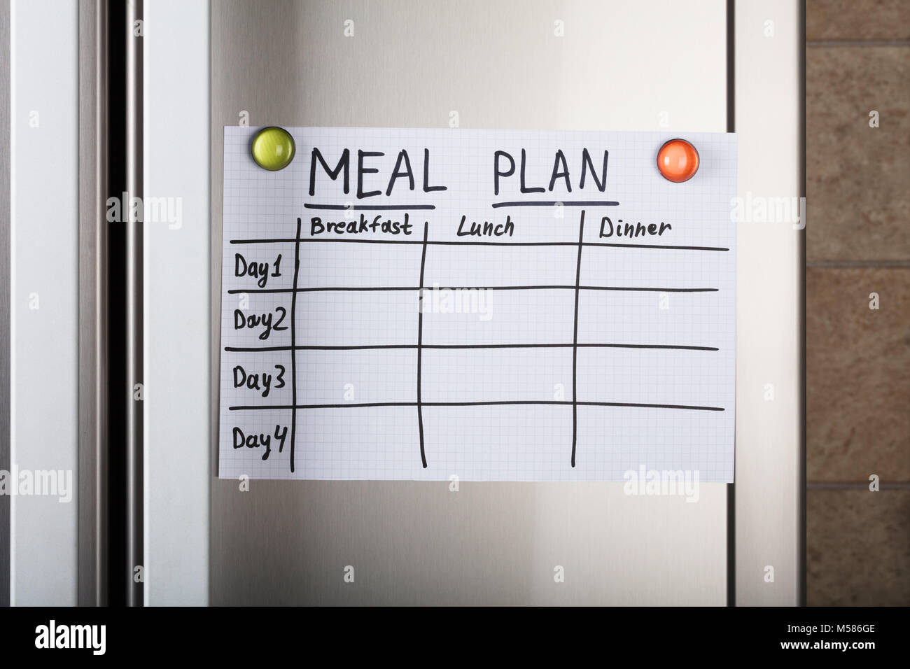 Nahaufnahme des täglichen Speisen Papier mit magnetischen Reißzwecken auf Metall Stockfoto