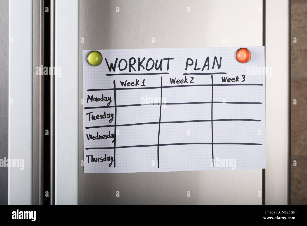 Nahaufnahme der wöchentlichen und täglichen Workout Plan Papier mit magnetischen Reißzwecken auf Metall Stockfoto