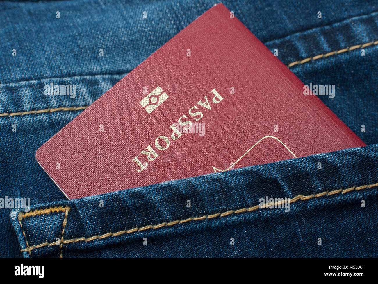 Rote Reisepass in der gesässtasche der Jeans. Stockfoto