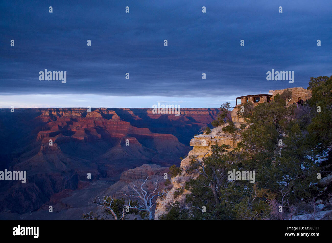 Grand Canyon National Park Yavapai Museum für Geologie. Sonntag, März 3, 2013 - Ein schwaches Tiefdruckgebiet eine Decke von Wolken in den Canyon brachte am Nachmittag, wodurch ein dunkler und gedämpfter Sonnenuntergang. Yavapai Museum für Geologie, eine Meile östlich (1,6 km) von der Plaza entfernt, bietet einen spektakulären Ausblick auf den Grand Canyon. Geologische zeigt gehören dreidimensionale Modelle, Fotografien und Hinweisschilder, die Park Besucher zu sehen und die komplizierte geologische Geschichte der Region verstehen. Das Yavapai Exponate erläutern die Ablagerung der Gesteinsschichten, die Hebung der Colora Stockfoto