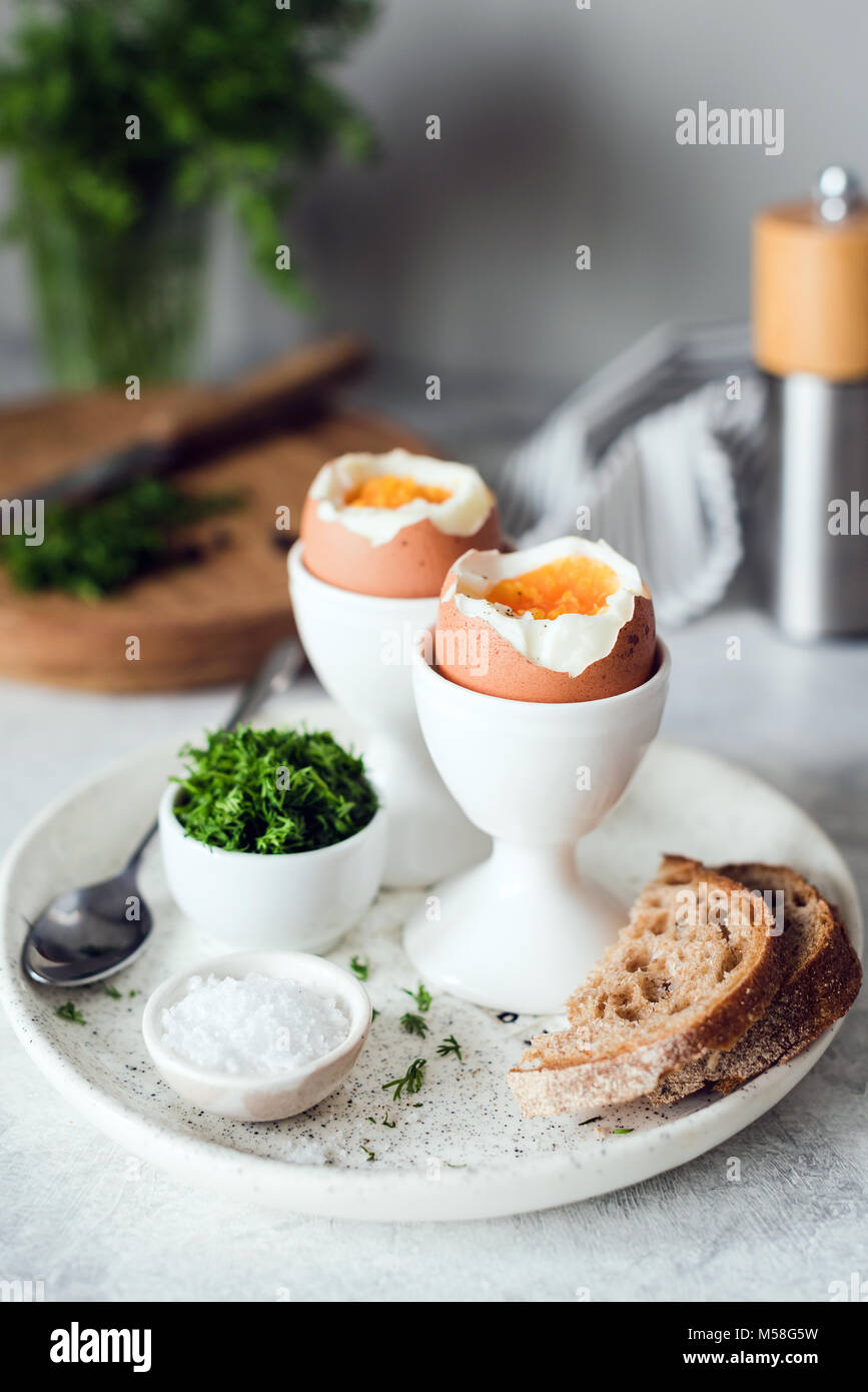 Frühstück mit gekochten Eiern und Toast. Vertikale, selektiver Fokus Stockfoto
