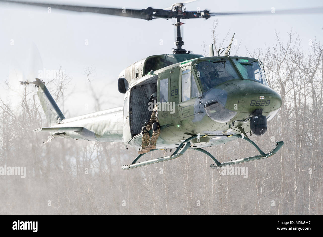 Ein 54 Helicopter Squadron UH-1N Iroquois schwebt über dem Turtle Mountain State Forest, N.D., 14.02.2018, während der 91St Sicherheitskräfte Feld Gruppe Training. Während die FTX, Verteidiger vektorisierte das Flugzeug auf eine Landing Zone und führten einen simulierten medizinische Evakuierung. (U.S. Air Force Foto von älteren Flieger J.T. Armstrong) Stockfoto