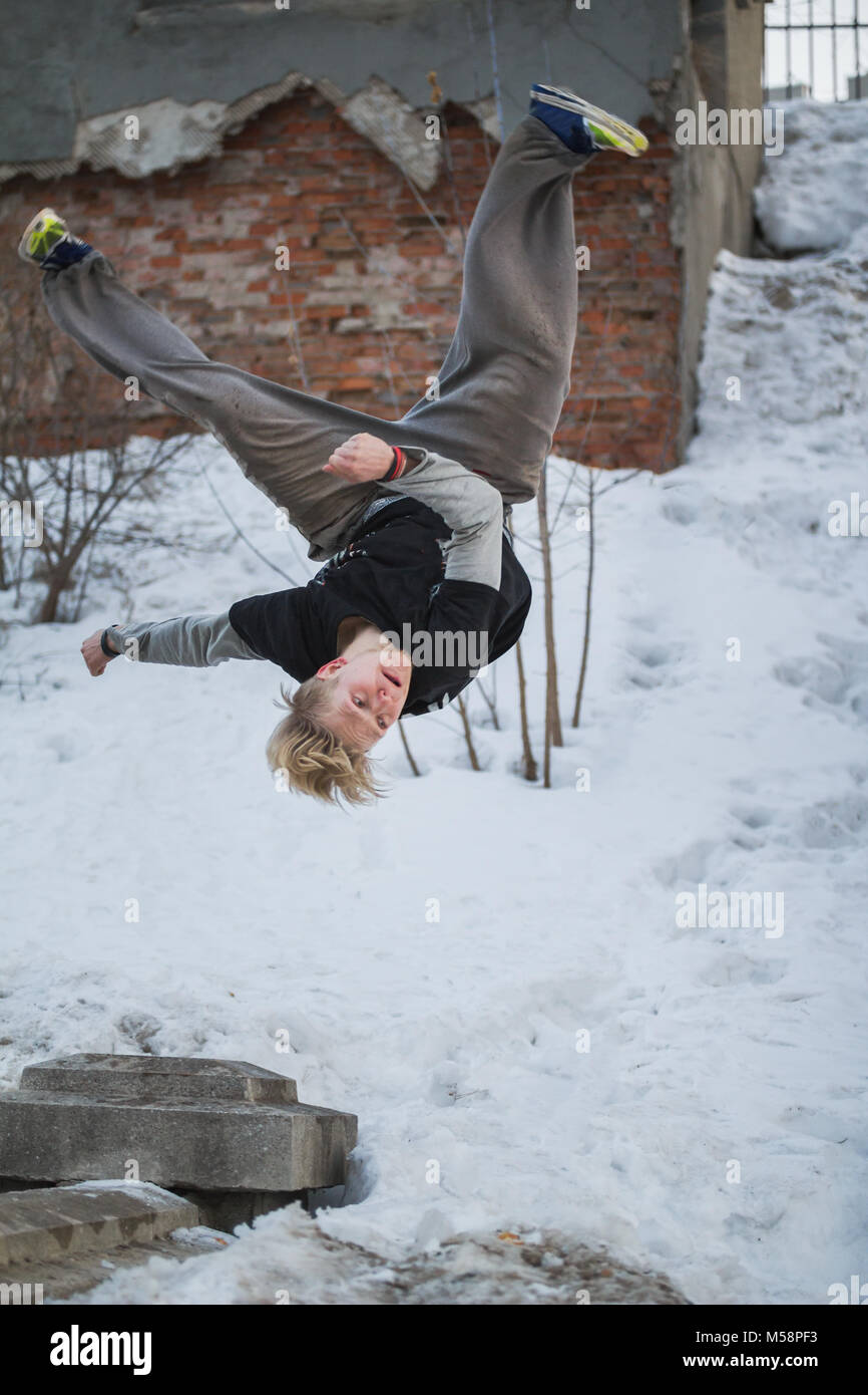 Backflip parkour im Winter Schnee Park-blondes Haar Teenager Stockfoto