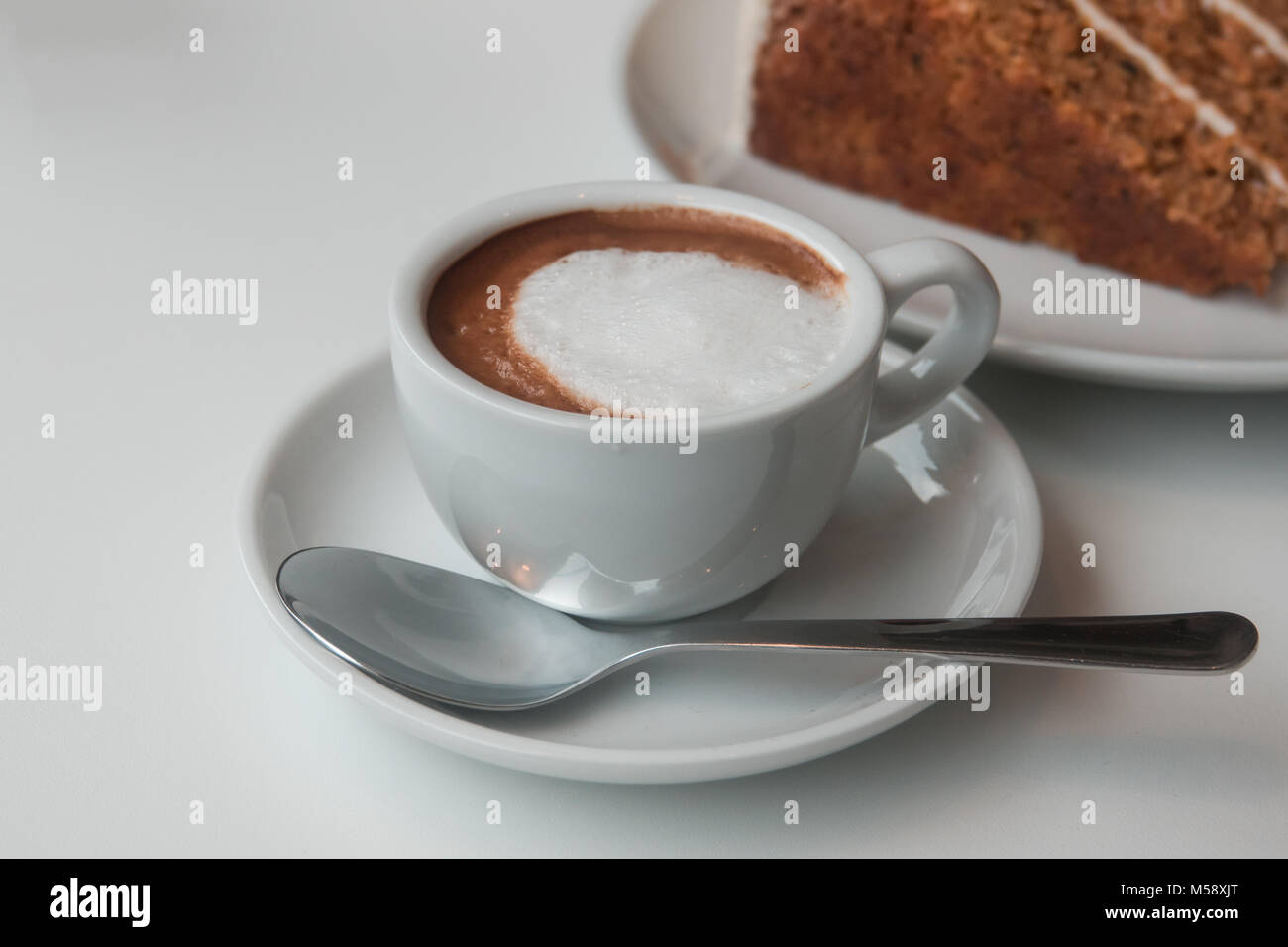 Eine Tasse Espresso Macchiato Kaffee und ein Stück Karottenkuchen Stockfoto