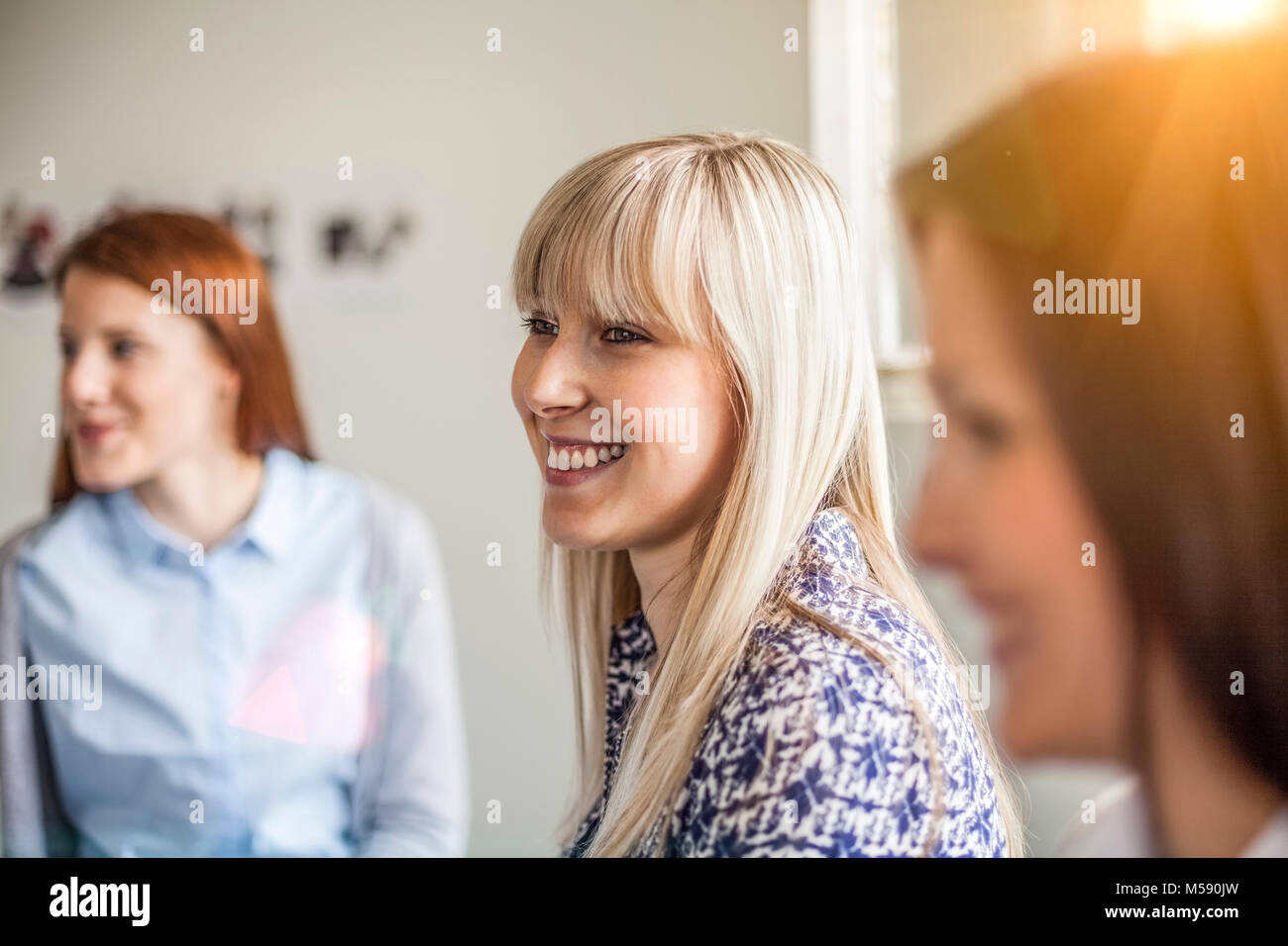 Lächelnden jungen Geschäftsfrau mit weiblichen Kollegen im Büro Stockfoto