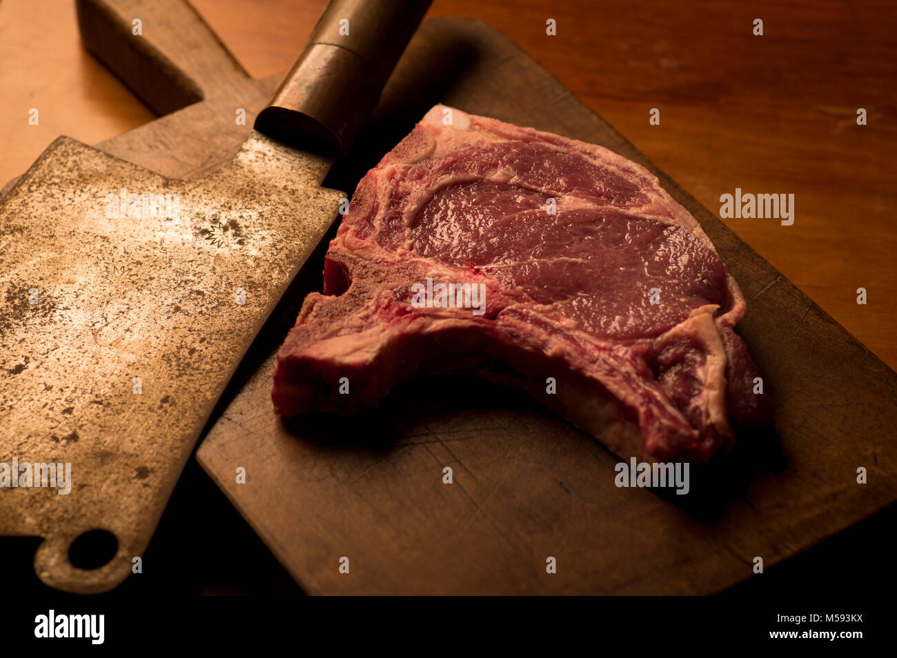 T-bone Roastbeef Steak mit einem Vintage Cleaver auf einem Schneidebrett Stockfoto