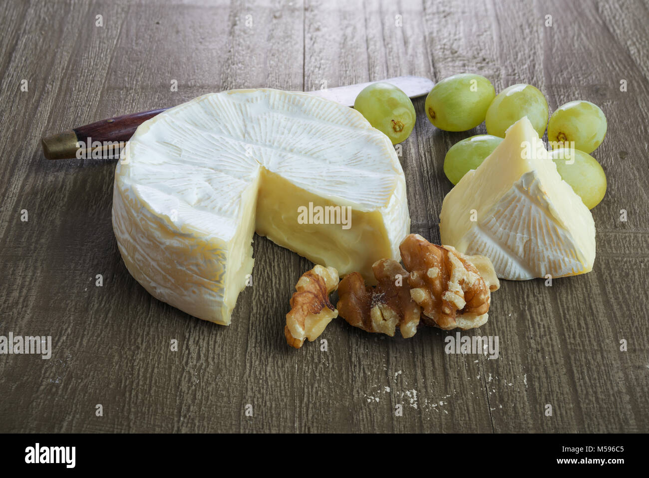 Frische brie Käse mit Trauben und Walnüssen auf retro Holztisch Stockfoto