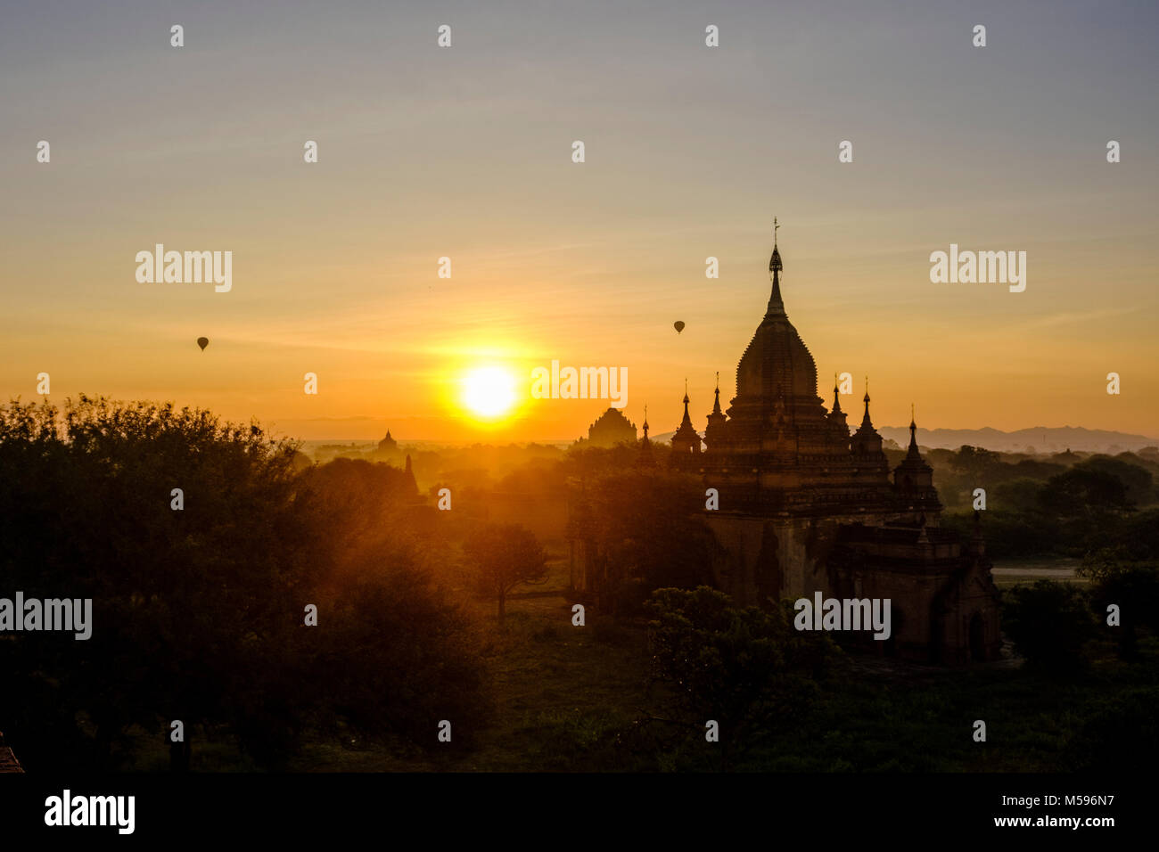 Heißluft-ballons Fliegen über den Pagoden von Bagan und den nebligen Ebenen der archäologischen Stätte in der Sunrise Stockfoto