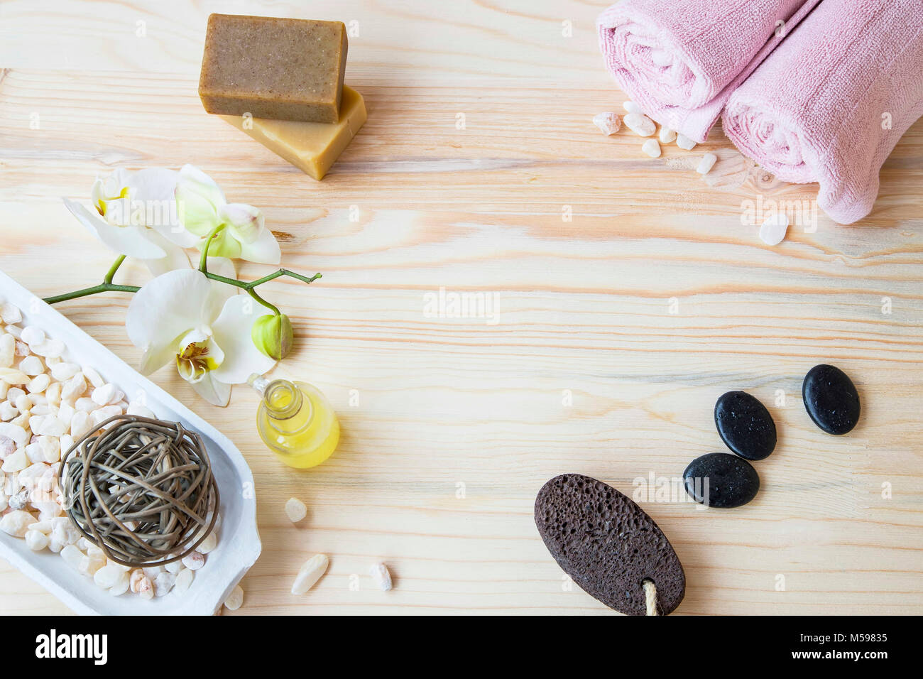 Noch immer leben flatlay Spa mit Spa Produkte, Badesalz, Badeöl, Orchidee, Blumen, natürliche Seifen, Handtücher aus Baumwolle und Massage Steine auf Holz- Hintergrund Stockfoto