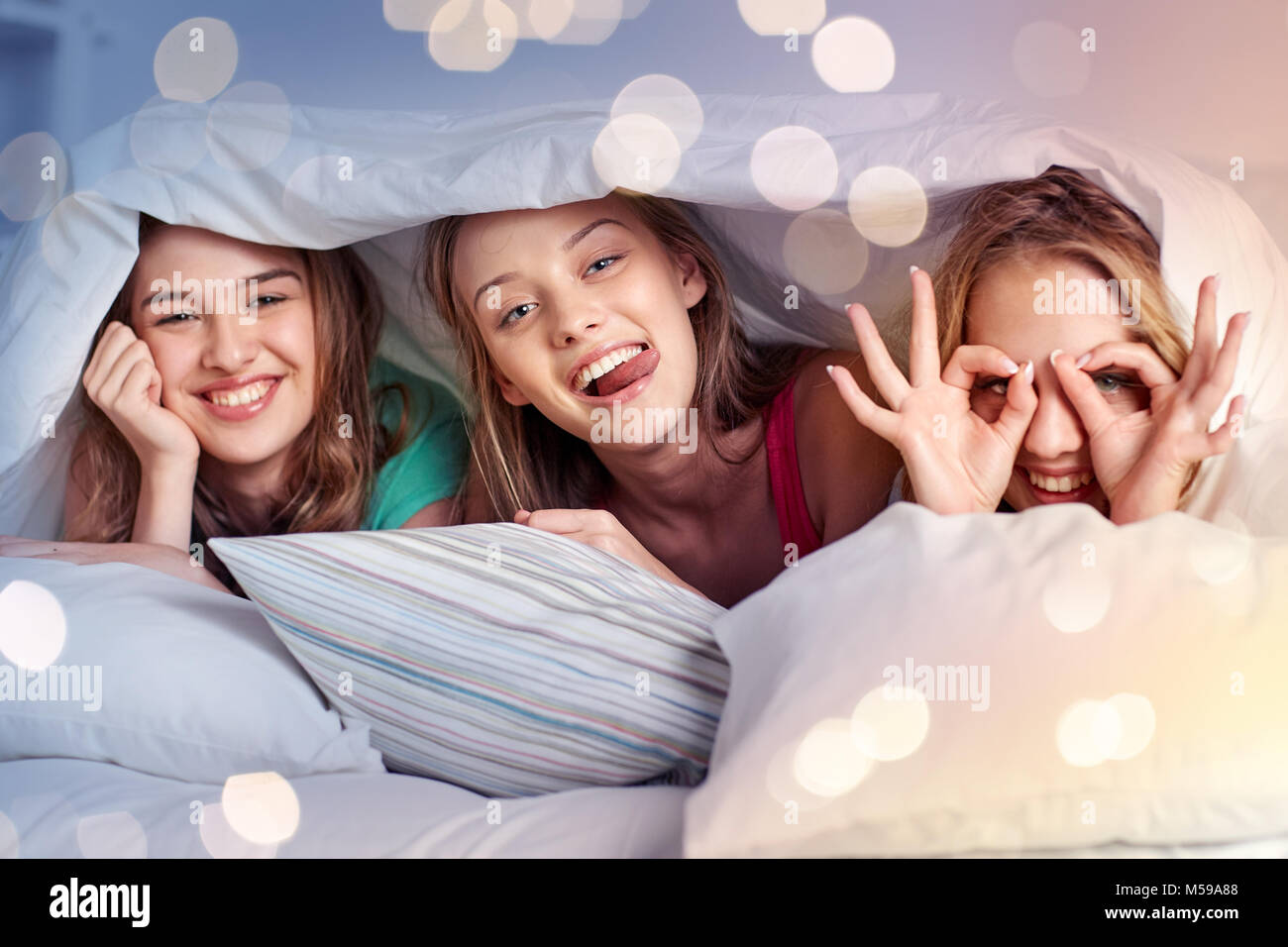 glückliche junge Frauen im Bett zu Hause Pyjama-party Stockfoto