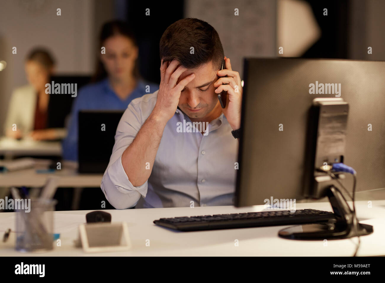Unternehmer fordern sartphone nachts Büro Stockfoto