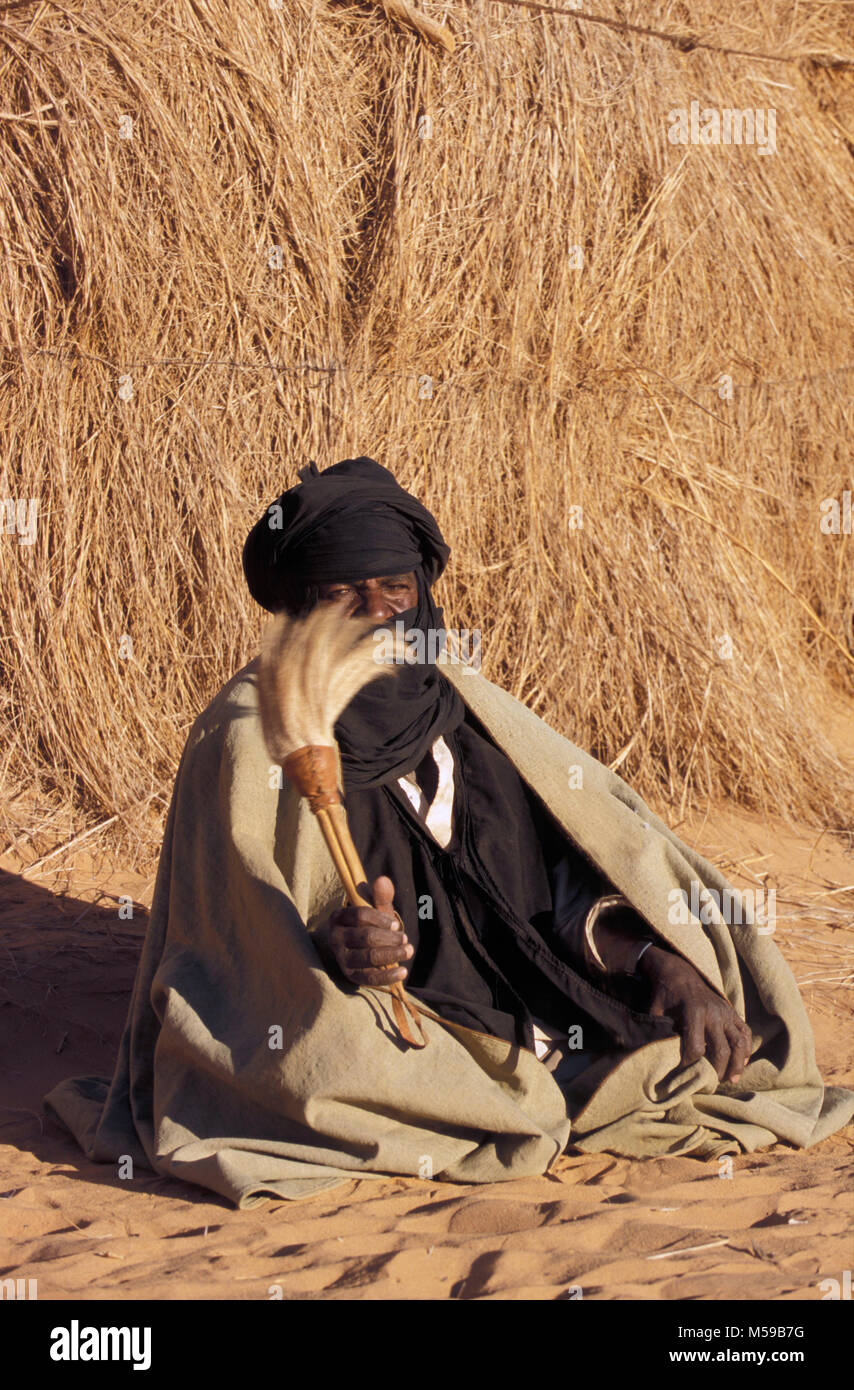 Libyen. In der Nähe von Ghat. Sahara. Akakus (acacus) National Park. Mann der Tuareg Stamm vor seinem Haus aus Stroh (zeriba). Stockfoto