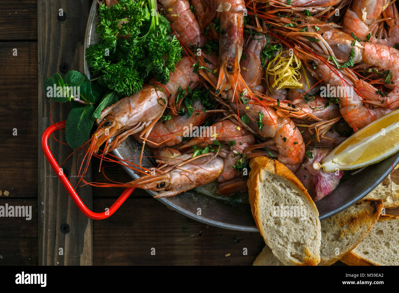 Tiger Garnelen in paella Pfanne mit Zitrone und Brot. Stockfoto