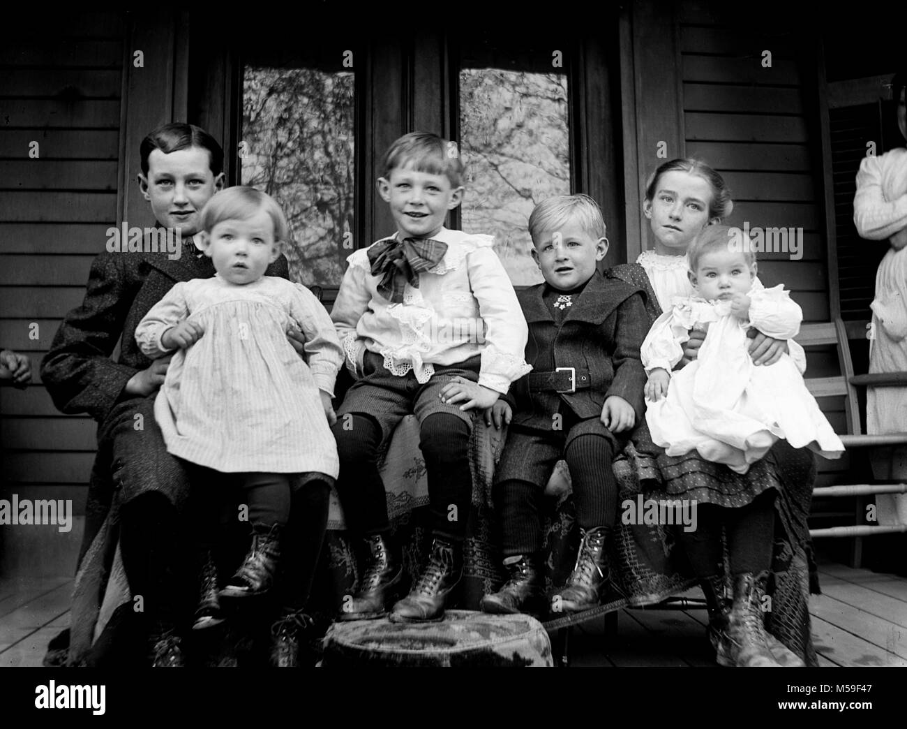 Die Kinder sammeln für eine formelle Portrait auf der Veranda, Ca. 1900. Stockfoto