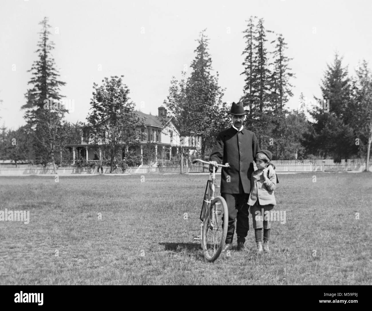 Vater und Sohn Pause während Sie reiten ihr Fahrrad in 1900s American. Stockfoto