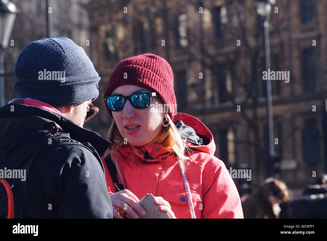 Junges Paar Sightseeing am Tag eines hellen Winter miteinander sprechen, warme Kleidung tragen, Trafalgar Square, London Stockfoto