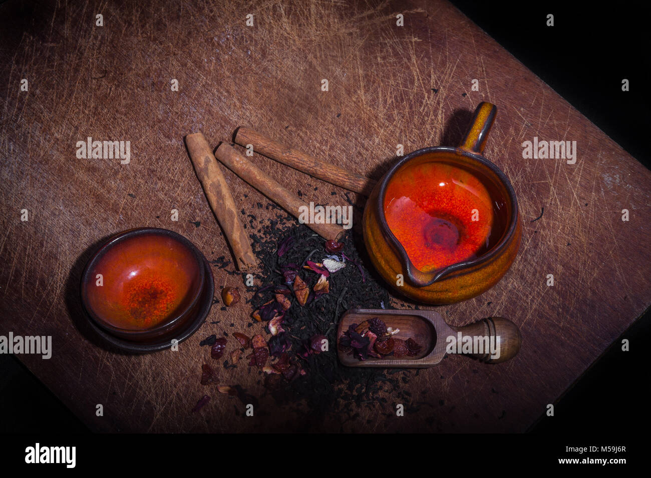Alte Keramik Tassen und Kaffee Glas auf Holzbrett mit Tee Blätter und Aromen - Schuß von oben Stockfoto