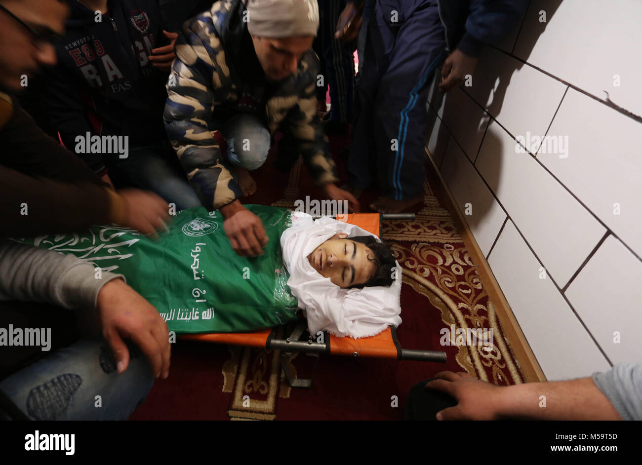 Rafah, Gaza, palästinensischen Gebiet. 21 Feb, 2018. Palästinenser sammeln über den Körper von Ahmed Ebu Helou, 19, der an seinen Verletzungen starb, nachdem israelische Sicherheitskräfte schossen ihn bei Auseinandersetzungen gegen die Entscheidung der US-Jerusalem als Hauptstadt Israels zu erkennen, während seiner Beerdigung, in al-bureij Flüchtlingslager, in der Mitte des Gazastreifens am 21 Februar, 2018 Credit: Ashraf Amra/APA-Images/ZUMA Draht/Alamy leben Nachrichten Stockfoto