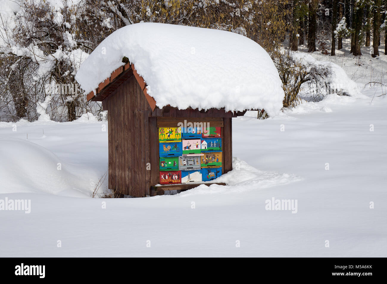 Bienenstock im Winter - Bienenstock Holz Haus bedeckt mit frischem Schnee, Bienenzucht Stockfoto
